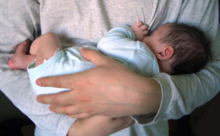 младенец на руках у родителя
