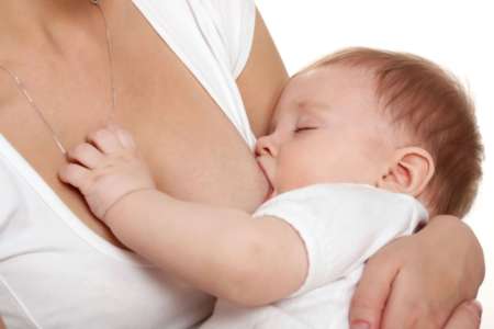 Женщина кормит малыша грудью